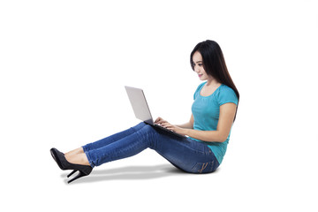 Young woman with laptop sitting on floor