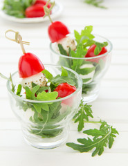 Salad with arugula, mozzarella and tomatoes.