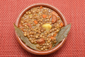 Brown lentil stew in bowl with vegetable