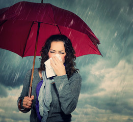 Sneezing Woman with Umbrella over Autumn Rain Background