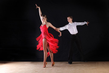 dancers in ballroom against black background
