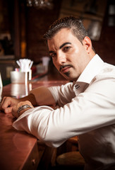 Closeup portrait of man in white shirt sitting near bar desk