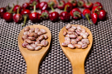 wooden spoons with bean seeds and red pepper