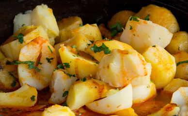Boiled potato in sauce with persley for decoration