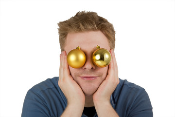 Lächelnder Mann mit Christbaumkugeln vor den Augen