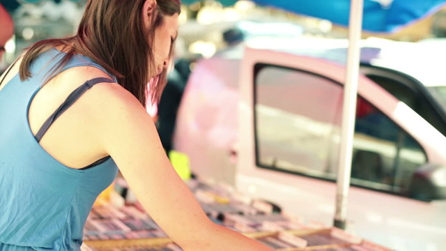 Woman looking at old dvd at city market