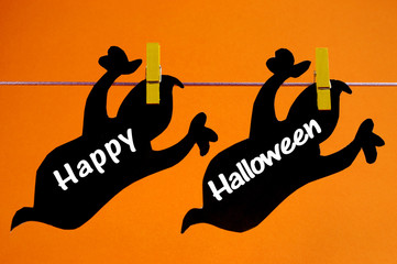 Happy Halloween bunting with black ghosts on orange background