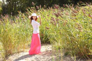 girl in a hat on a background summer landscape