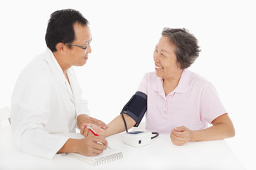 doctor measuring blood pressure of female patient