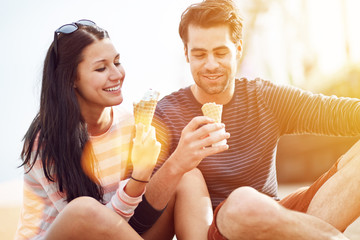 romantic couple eating ice cream at park