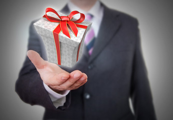Businessman showing a gift box