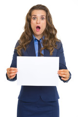 Fototapeta premium Surprised business woman showing blank paper sheet