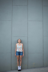 Fototapeta na wymiar Attractive woman standing in front of a grey wall