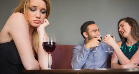 Blonde woman feeling envious of two people are flirting beside h