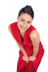 Cheerful mysterious brunette in red dress posing