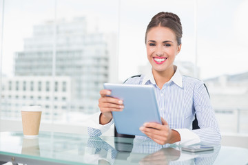 Attractive brunette businesswoman holding tablet