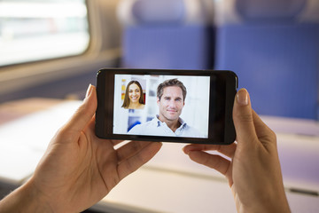 Fototapeta na wymiar Closeup of a female hand holding a cell phone during a skype vid