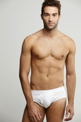 Fototapeta premium Portrait of mid adult man in briefs, studio shot