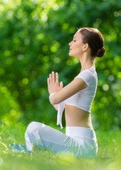 Profile of woman who sits in lotus position prayer gesturing - 56985702