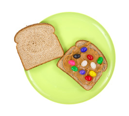 An open peanut butter jelly bean sandwich on a green plate