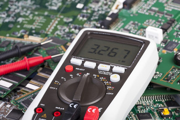 Digital Multimeter liegt auf Platinen