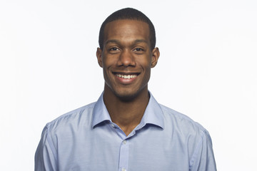 Young black man smiling against white background