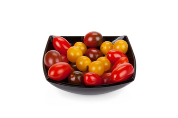 Cherry tomatoes in black plate isolated on white background