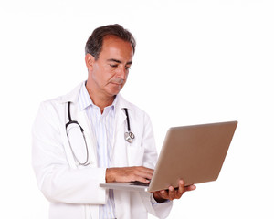 Mature doctor working on his laptop