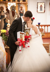 newly married couple kissing in orthodox church