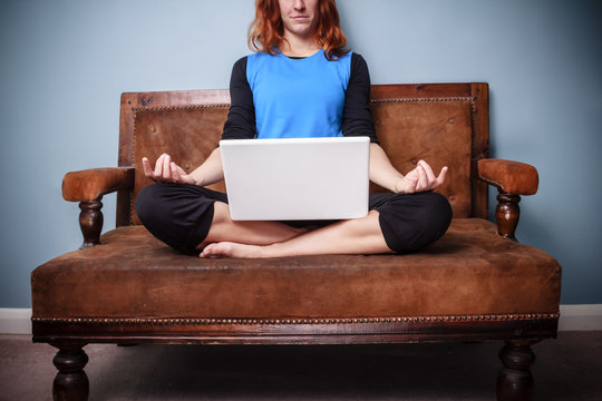 Spiritual woman sitting on sofa using her laptop