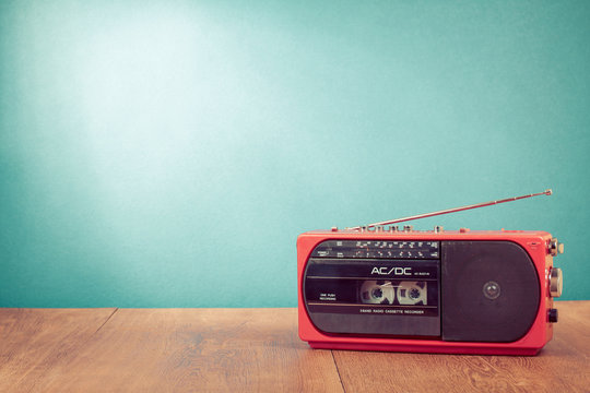 Retro red radio cassette player in front mint green background