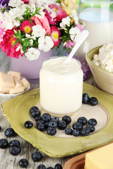 Fresh dairy products with blueberry on wooden table close-up