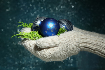 Female hands  in mittens Christmas tree balls,