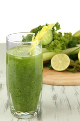 Glass of green vegetable juice and vegetables