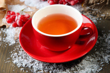 Still life with viburnum  tea in cup, berries and snow,