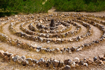 Fototapeta na wymiar Atlantis spirala znak Ibiza z kamieni na ziemi