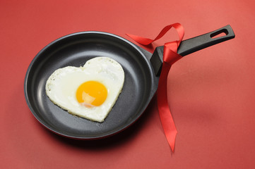Red theme Valentine heart shape egg in fry pan