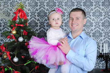 Small girl with father near fir trees