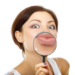 funny woman looking through a magnifying glass over white