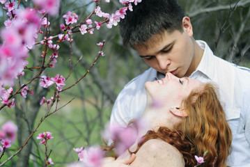 beautiful young couple in love among the flowering trees