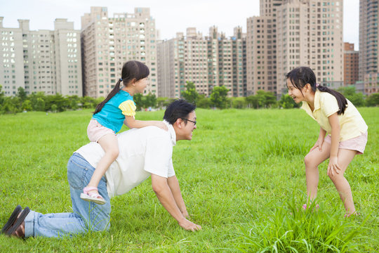 happy  father playing with daughters in the city park