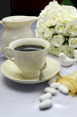 Fototapeta na wymiar Cup of coffee on wedding table with sugar almonds