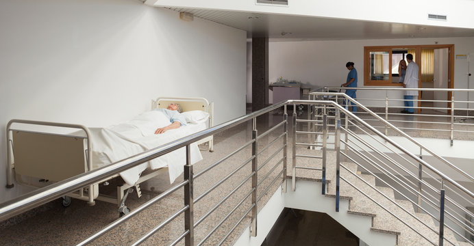 Patient lying in bed in quiet corridor