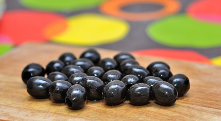 Obraz na płótnie Canvas Black olives on cutting board
