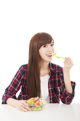 smiling young woman eating fruits and salad