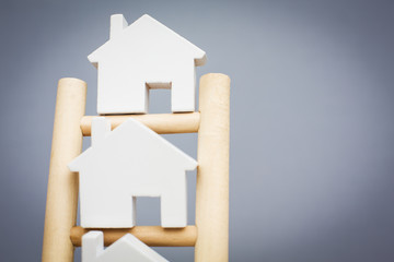 Model Houses On Rungs Of Wooden Property Ladder - obrazy, fototapety, plakaty