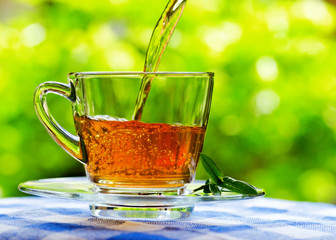 Cup of tea on nature background