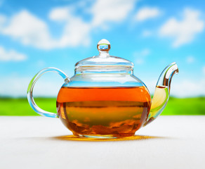 Teapot of fresh tea on natural background