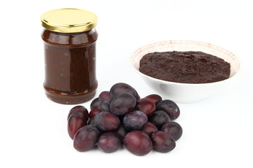 The jam and the plums on the white background