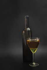 Bottle of wine and wine glass on black background